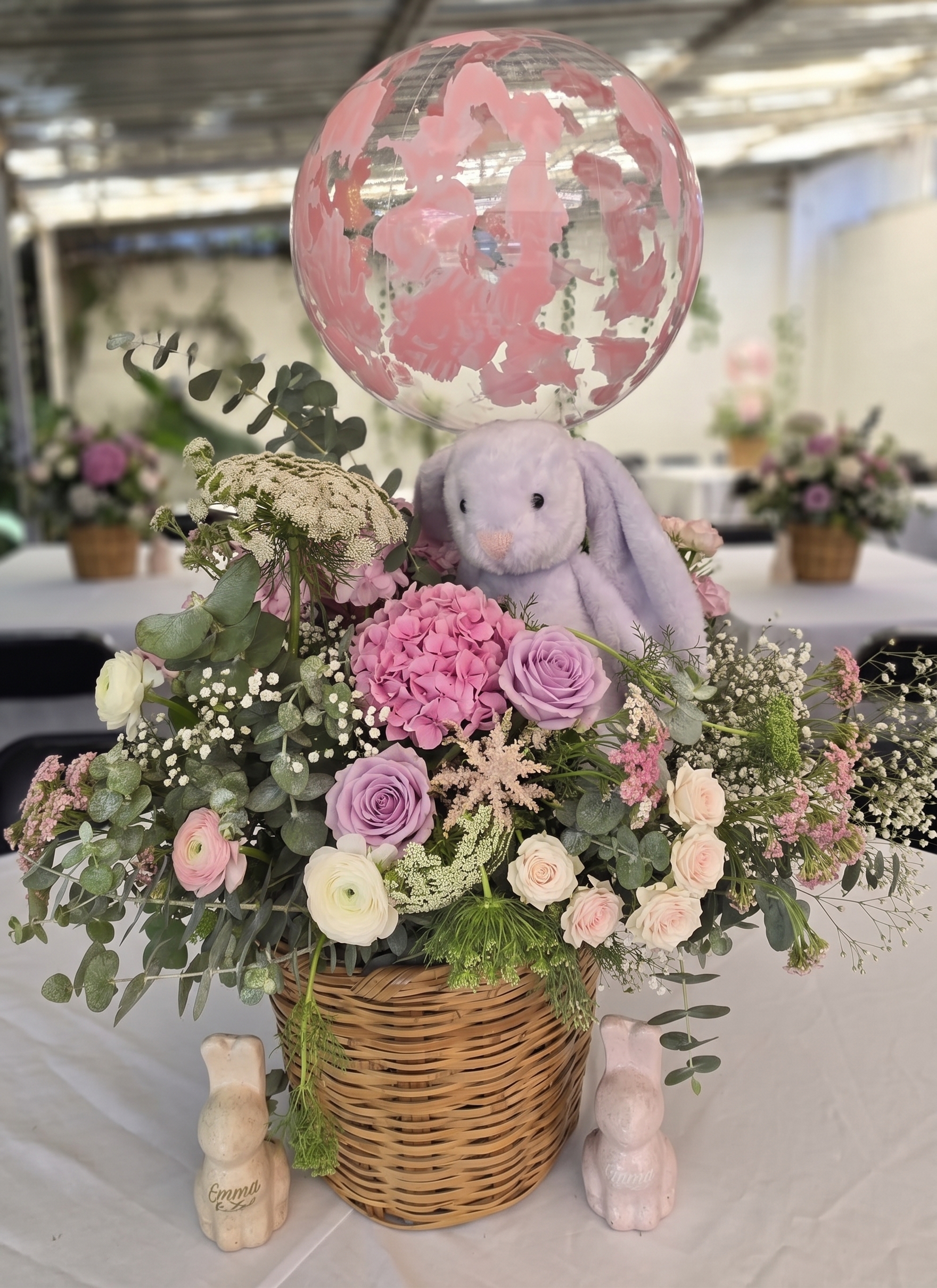 Centro de mesa con canasta floral, peluche y globo burbuja